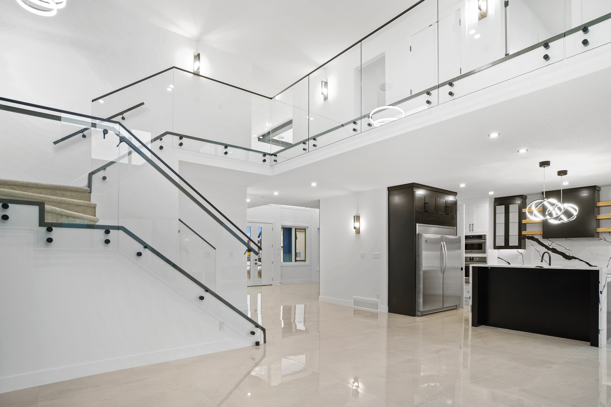 A modern home with a staircase and glass railings.